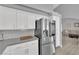 Bright kitchen with stainless steel refrigerator, white cabinets, stone countertops, and wood flooring at 5433 Escallonia St, Las Vegas, NV 89149