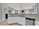 Well-appointed kitchen includes white cabinets, stone counters, stainless appliances, and a view to the dining area at 5433 Escallonia St, Las Vegas, NV 89149