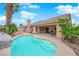 Private backyard features a sparkling pool, a stone waterfall and desert landscaping at 5433 Escallonia St, Las Vegas, NV 89149