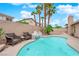Inviting backyard pool area with a waterfall feature and seating under the shade of palm trees at 5433 Escallonia St, Las Vegas, NV 89149