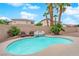 Backyard pool featuring a rock waterfall, surrounding palm trees, and chairs at 5433 Escallonia St, Las Vegas, NV 89149