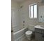A bright bathroom features a shower-tub combo, grey vanity with sink, toilet, and window for natural light at 5436 Burkshire Dr, Las Vegas, NV 89142