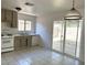 Functional kitchen with white appliances and tile floors, plus sliding door access to outside at 5436 Burkshire Dr, Las Vegas, NV 89142