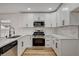 Well-lit kitchen showcasing white cabinets, stainless steel appliances, and stylish backsplash at 5466 Silverheart Ave, Las Vegas, NV 89142