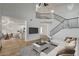 Bright, open-concept living room featuring a staircase and modern furnishings, flowing into the dining and kitchen area at 5466 Silverheart Ave, Las Vegas, NV 89142