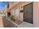 Townhome exterior showcasing a secure black metal front door with minimal desert landscaping and a light peach facade at 5939 Vegas Dr, Las Vegas, NV 89108