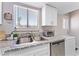 The kitchen features stainless steel appliances, granite countertops, white cabinetry and backyard access at 5939 Vegas Dr, Las Vegas, NV 89108