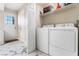 Well-lit laundry room with washer, dryer, shelving, and marble-look tile floor at 5939 Vegas Dr, Las Vegas, NV 89108