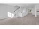 Hallway with neutral carpet leading to the staircase, enhanced by natural light and neutral tones at 6142 Kelson Creek Ct, Las Vegas, NV 89118
