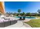 Relaxing backyard oasis with a pool, lounge seating, and a lush green lawn, perfect for entertaining at 6419 Eldora Ave, Las Vegas, NV 89146