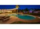 Beautiful backyard pool and spa with rock waterfall feature, surrounded by lush landscaping at night at 6419 Eldora Ave, Las Vegas, NV 89146