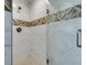 Clean shower with updated fixtures, glass door, and decorated accent tiles at 6419 Eldora Ave, Las Vegas, NV 89146