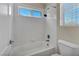 Bathroom featuring a white tiled tub and shower combo at 6424 Grayback Dr, North Las Vegas, NV 89084