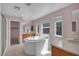 Bright bathroom featuring a large soaking tub, dual sinks, and tile flooring at 6424 Grayback Dr, North Las Vegas, NV 89084