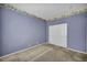 Carpeted bedroom features floral wallpaper border and closet with double doors at 6424 Grayback Dr, North Las Vegas, NV 89084
