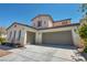 Home showcasing a two-car and one-car garage, beautiful desert landscaping, and blue skies at 6424 Grayback Dr, North Las Vegas, NV 89084