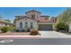 Inviting two-story home features a neutral color palette, red tile roof, and manicured landscaping at 6424 Grayback Dr, North Las Vegas, NV 89084