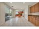 Bright kitchen with tile flooring, wood cabinets, and a sliding glass door to the backyard at 6424 Grayback Dr, North Las Vegas, NV 89084