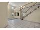 Elegant living room boasts tile floors, a staircase, and ample natural light, creating an open and inviting space at 6424 Grayback Dr, North Las Vegas, NV 89084