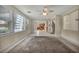Sunlit living room with large windows, open to kitchen and staircase at 6424 Grayback Dr, North Las Vegas, NV 89084