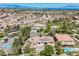 Luxury home with a pool, large backyard, and desert landscaping, surrounded by lush greenery and community amenities at 764 Ricota Ct, Henderson, NV 89012