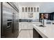 Charming kitchen features stainless fridge, white cabinets, wine rack, light countertop, and sink at 764 Ricota Ct, Henderson, NV 89012
