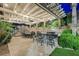 Outdoor patio with a covered pergola, string lights, a dining set, an outdoor kitchen, and a rock waterfall pool feature at 764 Ricota Ct, Henderson, NV 89012