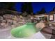 Backyard pool featuring a rock waterfall, integrated spa, and covered outdoor dining area at 764 Ricota Ct, Henderson, NV 89012