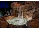 Picturesque backyard waterfall feature with cascading water over natural rock formations at night at 764 Ricota Ct, Henderson, NV 89012