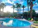 Beautiful community pool surrounded by palm trees and lounge chairs at 8000 Badura Ave # 2009, Las Vegas, NV 89113