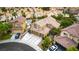 Bird's eye view of home with tile roof, three car garage and lush landscaping in a desert neighborhood at 8253 Ruby Mountain Way, Las Vegas, NV 89128