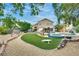 Lush backyard with a pool, spa, manicured lawn, and covered patio for entertaining at 8253 Ruby Mountain Way, Las Vegas, NV 89128