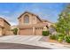 Charming two-story home featuring an attached three-car garage, desert landscaping, and a tiled roof at 8253 Ruby Mountain Way, Las Vegas, NV 89128