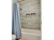 A tiled shower and tub include built-in niches, a shower curtain, and updated fixtures at 8253 Ruby Mountain Way, Las Vegas, NV 89128
