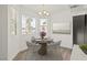 Bright dining area features a modern light fixture, a round table with seating for four, and large windows at 829 Rock Springs Dr # 201, Las Vegas, NV 89128