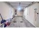 View of the empty garage with visible water heater, overhead storage and sealed concrete flooring at 9148 Alluring Ave, Las Vegas, NV 89149