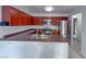 Well-lit kitchen boasts stainless steel appliances, rich wood cabinetry, and ample counter space at 9148 Alluring Ave, Las Vegas, NV 89149
