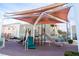 Community playground featuring slides and climbing structures under a sunshade canopy at 9148 Alluring Ave, Las Vegas, NV 89149