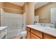 Bathroom with tile floor, shower-tub combo, white cabinets, and large mirror at , Henderson, NV 89044