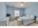 Light blue bedroom includes a ceiling fan, window, television, and a bed with a white comforter at , Henderson, NV 89044