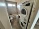 Bathroom showcasing laundry machines, a tub, and needed repairs, offering renovation possibilities at 1004 Stone River Dr, North Las Vegas, NV 89030