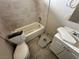 Bathroom with a tub, toilet, and damaged flooring, offering a renovation opportunity at 1004 Stone River Dr, North Las Vegas, NV 89030