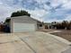 Single-story home with attached garage, long driveway, and low-water landscaping at 1004 Stone River Dr, North Las Vegas, NV 89030