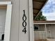 Close-up of house number '1004' on the exterior of the house near the front door at 1004 Stone River Dr, North Las Vegas, NV 89030