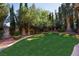 Lush green backyard with well-manicured lawn and mature trees at 1008 Trophy Hills Dr, Las Vegas, NV 89134
