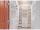 Walk-in closet with custom white shelving, storage drawers, and a dark wood door at 1008 Trophy Hills Dr, Las Vegas, NV 89134