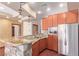 Modern kitchen features a stone breakfast bar, stainless steel refrigerator, and wood cabinets at 1008 Trophy Hills Dr, Las Vegas, NV 89134