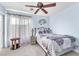 Cozy bedroom with a ceiling fan, a decorative wall piece, and a white and purple comforter at 10113 Walhalla Plateau Ct, Las Vegas, NV 89148