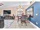Open dining area features a stylish chandelier, seating for six, with views of the large entertainment center at 10113 Walhalla Plateau Ct, Las Vegas, NV 89148