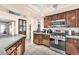 Well-lit kitchen showcasing tile floors, wood cabinets, modern appliances, and breakfast bar at 10113 Walhalla Plateau Ct, Las Vegas, NV 89148